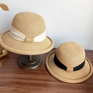 Details of the French straw sun hat featuring elegant bow and rolled brim for women.