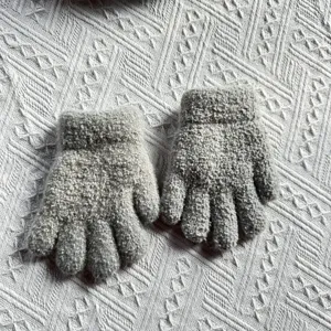 Children winter warm grey knitted gloves detail shot showing soft woolen texture cozy design.