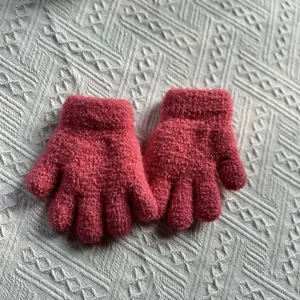 Details of the thick warm winter knitted gloves for kids, solid pink thermal glove close-up.