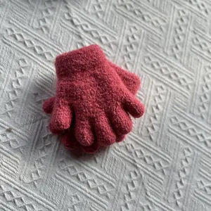 Close-up detail of warm thermal knitted gloves in vibrant pink designed for winter kids.