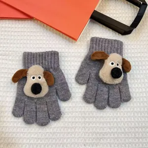 Close-up detail of winter children's knitted gloves featuring cute plush puppy cartoon design.