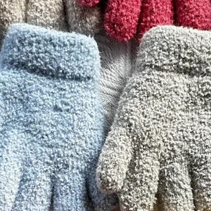 Close-up detail of cozy plush knitted winter gloves texture, soft warm fuzzy fabric display.