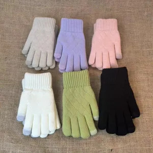 Knitted gloves detail view, soft woolen fabric with classic diamond pattern texture.