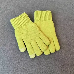 Close-up of lime green knit gloves featuring diamond pattern and ribbed cuffs for winter warmth.