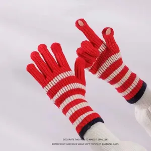 Detail view of red white striped knitted gloves winter warm touch screen long cuff design.