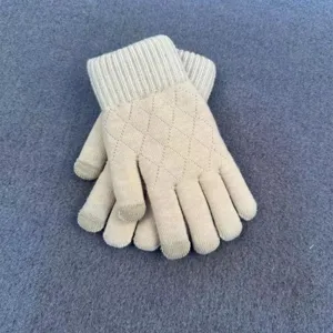 Detailed view of women's beige knit gloves featuring a chic diamond quilted pattern and warm touch.