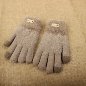 Primo piano dettagliato di caldi guanti touch screen in maglia invernale con polsini in peluche.