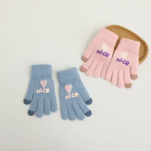 Detail view of winter warm knitted touch screen gloves for women with cute heart and nice pattern.