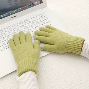 Green knitted touchscreen gloves for women winter warmth with quilted pattern detail close up