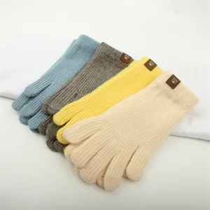 Detailed view of colorful winter knitted gloves with cute bear patch, warm and soft.