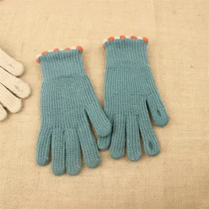 Close-up detail of women winter knit fingerless gloves with cozy ribbed cuff and cute trim.