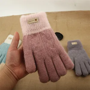Primo piano dettagliato di guanti invernali in morbida maglia spessa con polsino peluche.