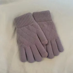 Close-up of winter knitted touchscreen gloves in mauve with elegant diamond grid pattern.