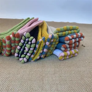 Close-up detail of colorful knitted winter gloves stacked together, warm fleece lined cozy style.