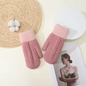 Dettaglio di moffole invernali calde in maglia da donna, guanti termici rosa accoglienti.