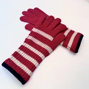 Detailed view of women's long knitted striped five-finger gloves, warm winter wear.