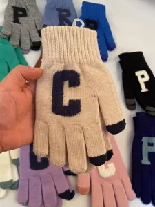 Gros plan détaillé de gants tactiles en tricot à lettres chauds d'hiver pour femmes en couleurs.