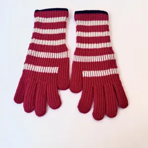 Detail view of red white striped knit winter gloves warm touchscreen long cuff design
