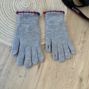Grey knit winter gloves for women, cute fingerless design with colorful dot cuffs for warmth.