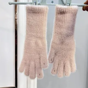Vue détaillée des gants longs en tricot rose dotés d'ouvertures pratiques pour les doigts.