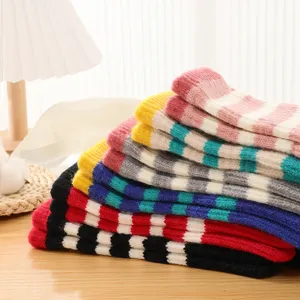 Detailed close-up of colorful striped knitted fingerless gloves, cozy winter arm warmers.