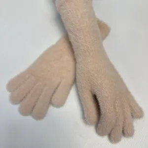 Gros plan détaillé des gants d'hiver longs et chauds en tricot, texture douce et fine.