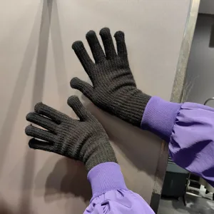Close-up detail of black knitted split-finger gloves with purple cuffs, warm and cozy.