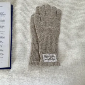 Close-up of cozy knit long fingerless gloves with elegant lace patch detail, autumn winter.