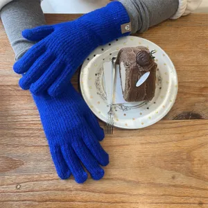 Detail shot of long winter knit gloves, showcasing soft blue fabric texture and cozy fit.