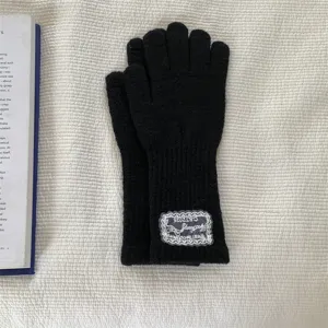 Detailed view of black knitted long touchscreen gloves featuring delicate lace patch decoration.
