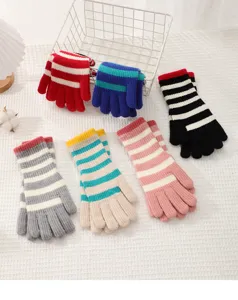 Detailed view of colorful striped knitted winter gloves, featuring cozy wool fabric for winter.