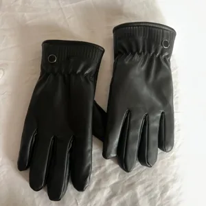 Detail view of black leather touch screen winter gloves with plush lining for cold riding.