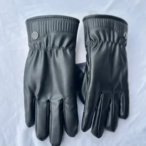 Close-up details of black leather winter gloves, showcasing warm plush lining and touchscreen.