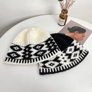 Vista dettagliata di cappelli a secchiello in maglia bicolore nero e bianco con motivo retrò.