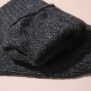 Gros plan de gants d'hiver tricotés pour hommes gris foncé avec un tissu en laine chaude.