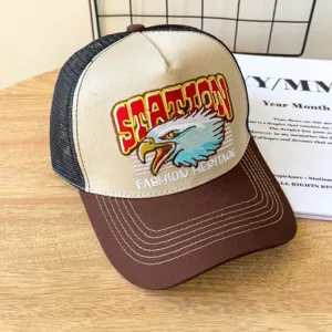 Vintage style embroidered trucker baseball hat featuring eagle graphic and mesh back panel detail.