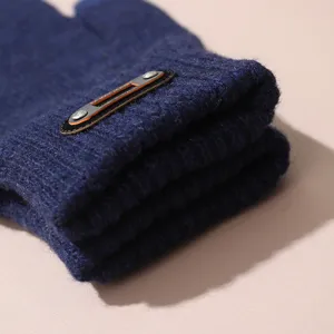 Gros plan détaillé de la manchette de gant tricoté avec texture en laine et écusson.