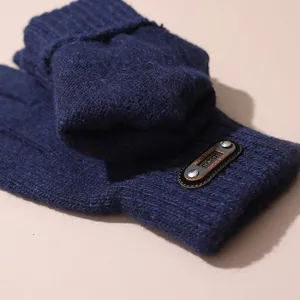 Vue détaillée de gants tricotés bleu foncé pour hommes, affichant texture fine et écusson.