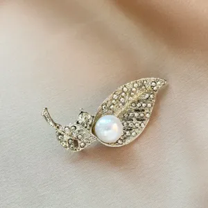 Elegant leaf brooch pin with sparkling rhinestones and a white faux pearl for women dress.