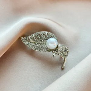 Detailed close-up of a elegant leaf-shaped pearl rhinestone brooch, luxury alloy jewelry accessory.