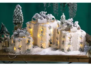 Pre-lit snowy Christmas gift box decorations with warm LED lights and pine cone accents