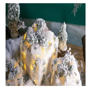 Close-up of glowing white Christmas gift boxes with snow coating and warm LED lights