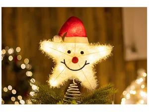 Warm glowing LED Christmas tree topper star with Santa hat on an evergreen tree branch