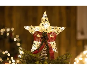Close-up of glowing iron Christmas tree topper star with red bow and LED lights