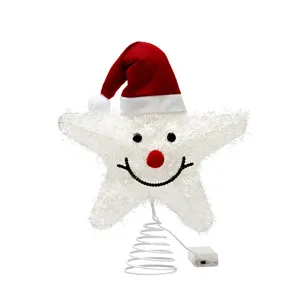 Close-up detail of white glowing LED Christmas tree star topper featuring a festive Santa hat