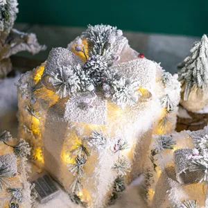 Glowing white Christmas gift box decorations with iron frames and warm LED lights for holiday.