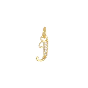 Dettaglio macro di un ciondolo a forma di lettera J placcato in oro 18K con zirconi incastonati