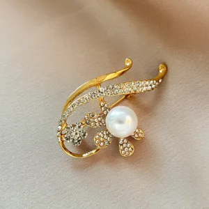 Élégante broche fleur perle strass dorée pour femmes, détail accessoire veste de costume.