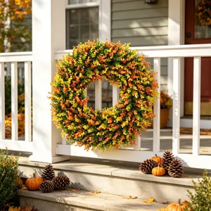 Vibrant artificial boxwood wreath with autumn colors hanging on a white porch railing