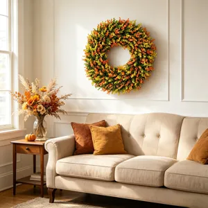Vibrant autumn leaf wreath hanging on a white wall above a beige sofa in a cozy room